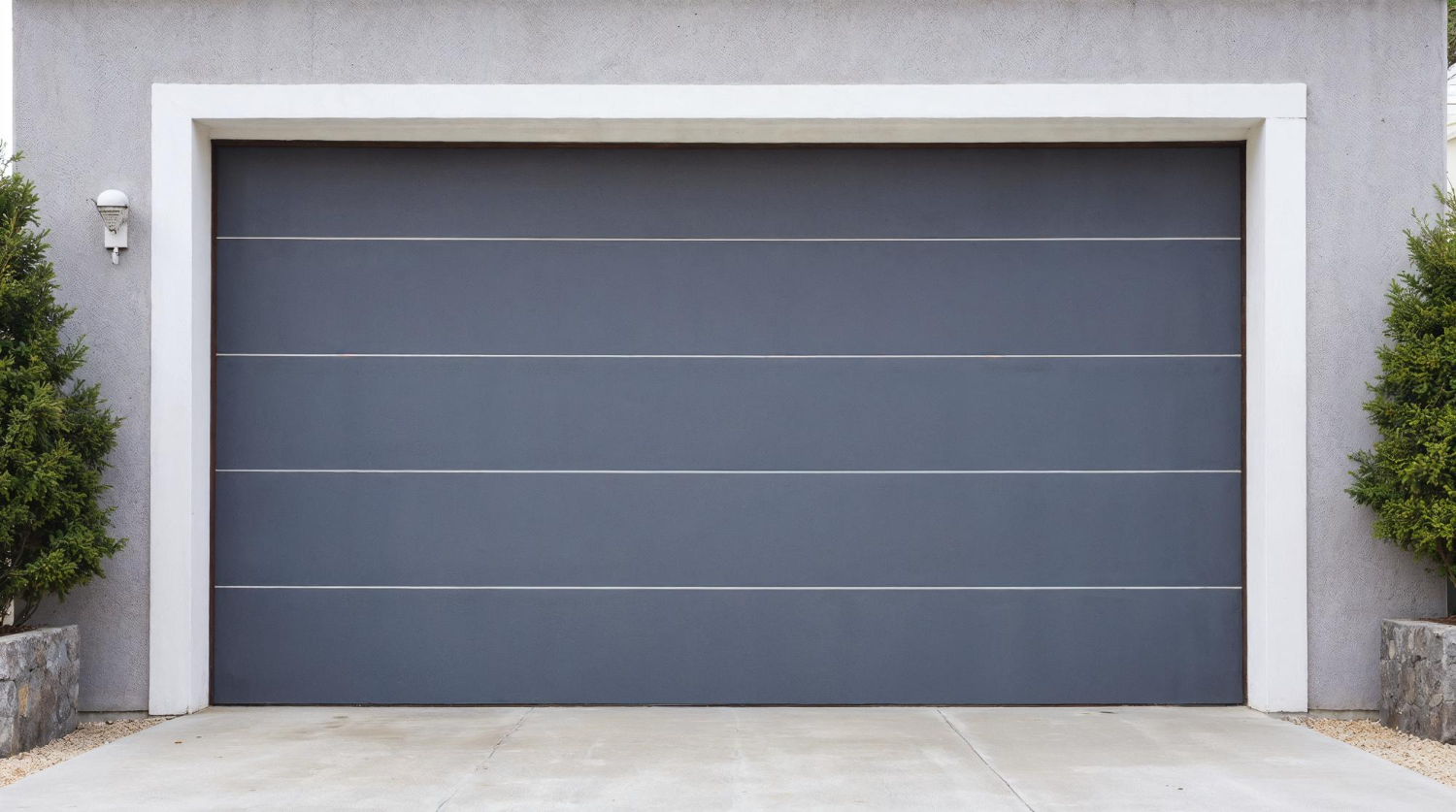 Une porte de garage moderne de couleur noire entourée d'arbres